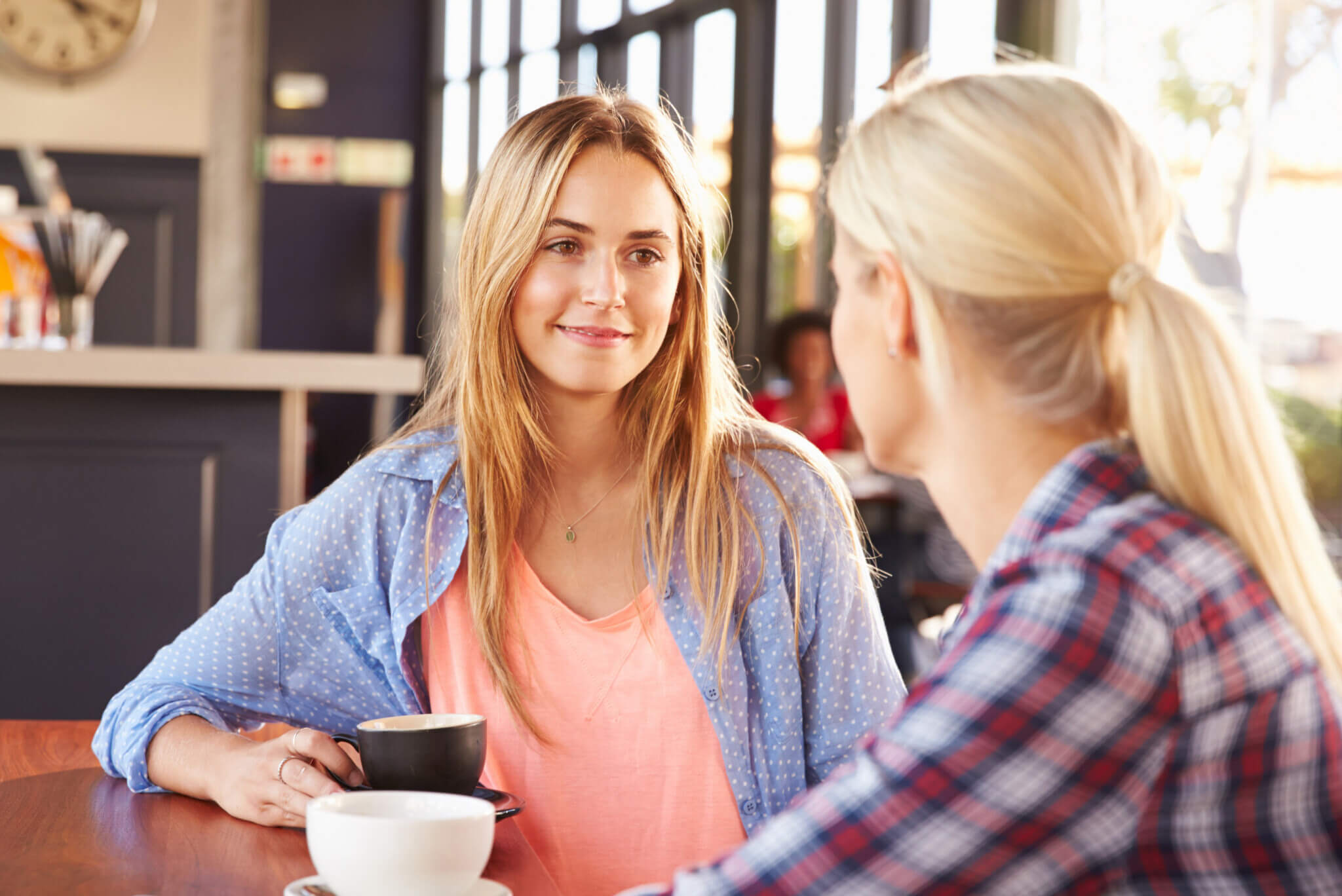 Two women having a meaningful conversation over cups of coffee